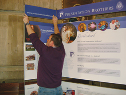 Fr&egrave;re Ray Dwyer, F.P.M. affiche un placard de publicit&eacute; vocationnelle pour les Presentation Brothers.